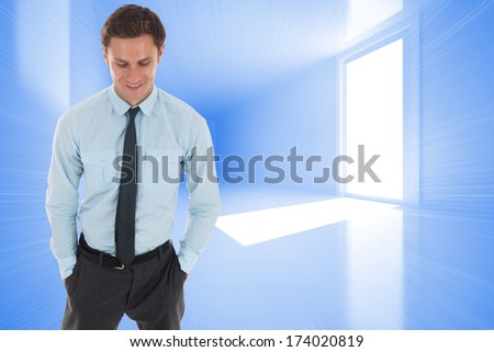 Happy businessman standing with hands in pockets against bright blue room with window