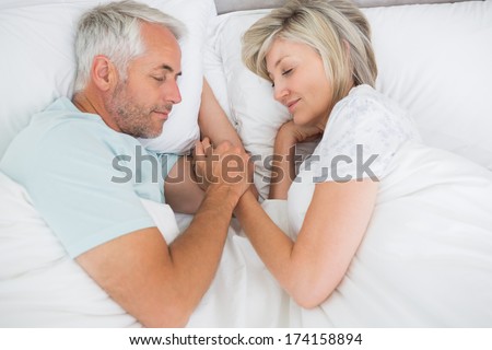 High angle view of a mature couple lying in bed at home