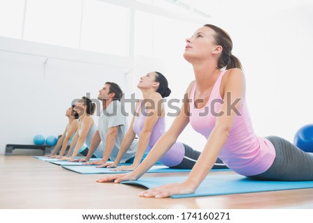 Side View Of A Fit Class Exercising In Row At Fitness Studio