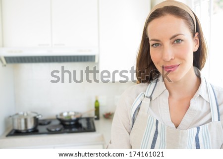 Closeup portrait of a smiling young woman in the kitchen at home