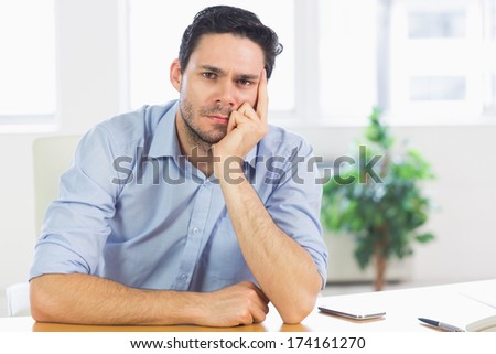 Portrait of thoughtful businessman at desk in office