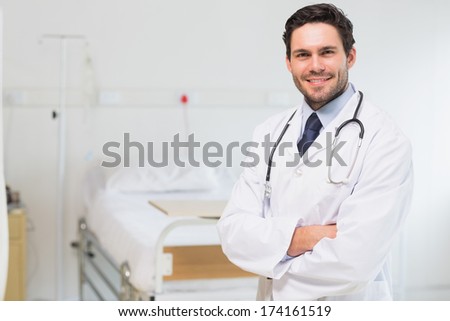 Portrait of confident doctor standing arms crossed in hospital room