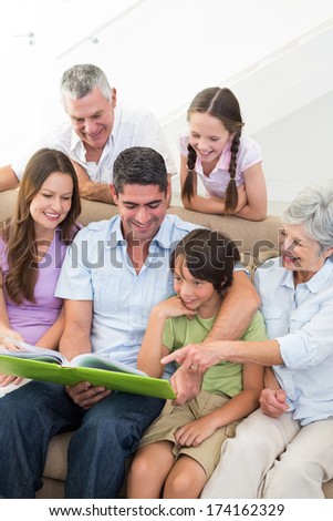 Happy multigeneration family reading book at home
