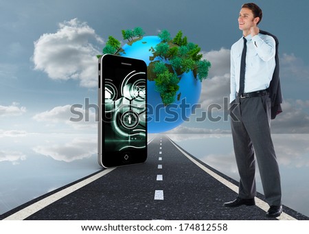 Smiling businessman holding his jacket against digitally generated earth floating over street