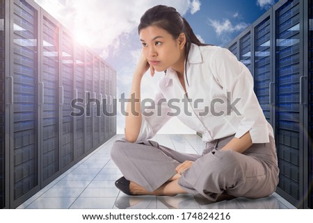 Businesswoman sitting cross legged against server hallway in the sky