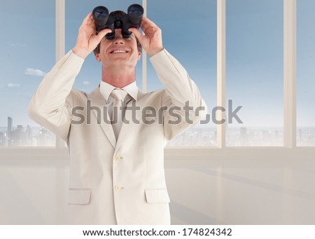 Confident businessman with binoculars against bright white room with windows