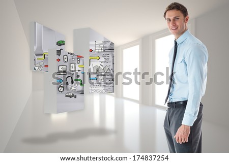 Smiling businessman standing with hand in pocket against bright hall with windows