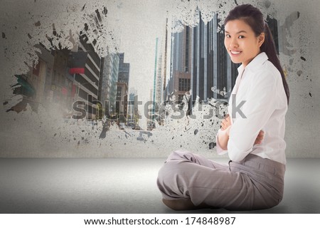 Businesswoman sitting cross legged with arms crossed against splash showing cityscape