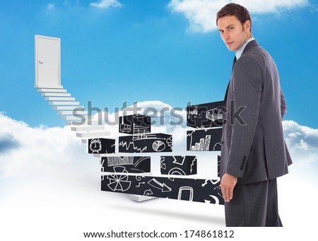 Serious businessman with hand on hip against steps leading to closed door in the sky