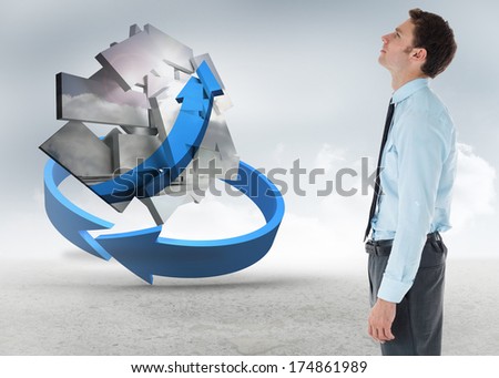 Serious businessman standing with hand in pocket against blue arrow in a desert landscape