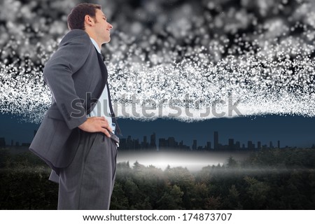 Cheerful businessman standing with hands on hips against bright stars of energy over landscape