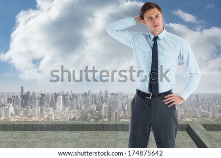 Thoughtful businessman with hand on head against balcony overlooking city