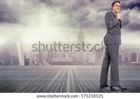 Thinking businessman with hand on chin against balcony overlooking city