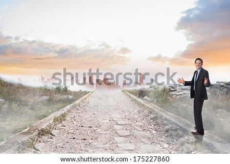 Stressed businessman gesturing against stony path leading to misty city horizon