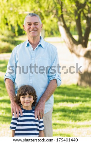 Portrait of a grandfather and son standing at the park