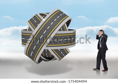 Stressed businessman with hands on head against tangled roads in a ball