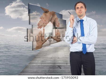 Thinking businessman holding pen against bridge in ocean under cloudy sky