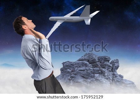 Businessman standing with arms pushing up against rocky landscape
