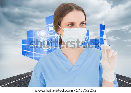 Pretty brunette female doctor holding a syringe and looking at it against cloudy landscape background with street