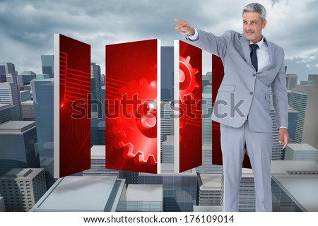 Handsome businessman pointing away against digitally generated cityscape