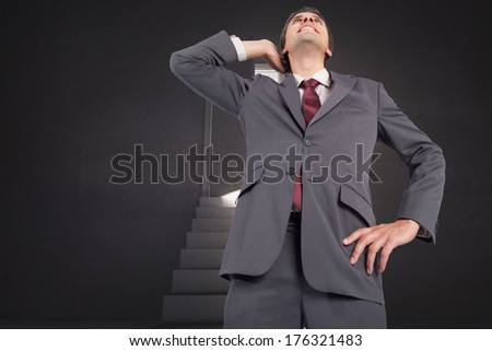 Thinking businessman scratching head against steps leading to door showing light