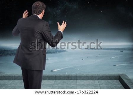 Stressed businessman gesturing against balcony overlooking coastline at night