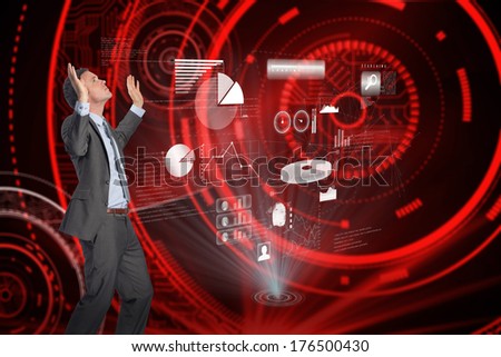 Businessman posing with arms raised against shiny red circles on black background