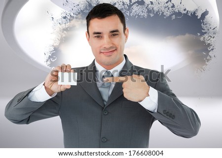 Businessman pointing at his businesscard against splash showing cloudy sky