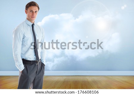 Serious businessman standing with hands in pockets against clouds in a room