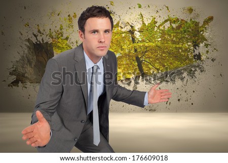 Businessman posing with hands out against splash on wall revealing forest trail