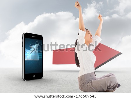 Businesswoman sitting cross legged cheering against red arrow in the sky
