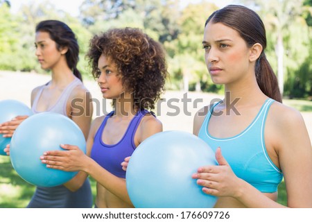 Multiethnic sporty women with medicine balls exercising in park