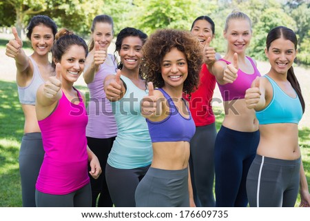 Portrait of successful sporty women gesturing thumbs up in park