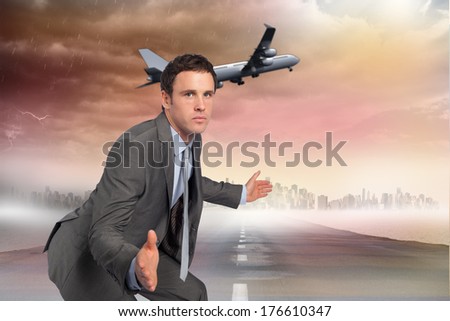 Businessman posing with hands out against road leading out to the horizon