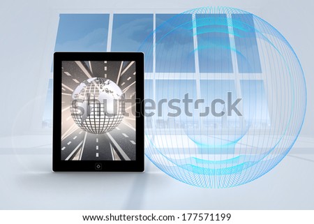 Silver globe on tablet screen against abstract blue design in white room