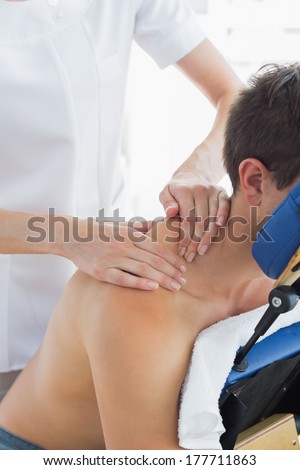 Man receiving shoulder massage by female therapist in hospital