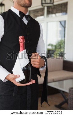 Waiter holding magnum of champagne in the patio of restaurant