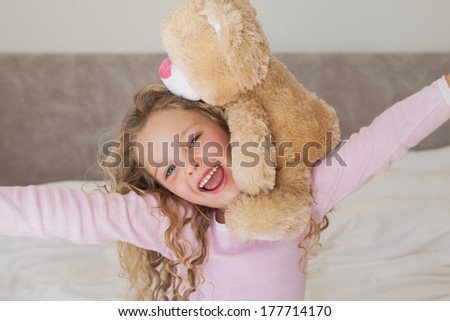 Close-up portrait of a young happy girl with stuffed toy