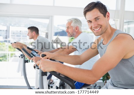 Portrait of handsome man on exercise bike in fitness club Portrait of handsome man on exercise bike in fitness club