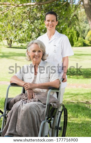 Portrait of a woman with her mature mother sitting in wheel chair at the park