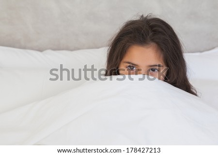 Portrait of a young girl resting in bed at home