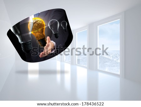 Light bulb graphic on abstract screen against bright white corridor with windows