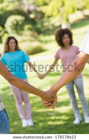 Close-up group of friends holding hands in the park