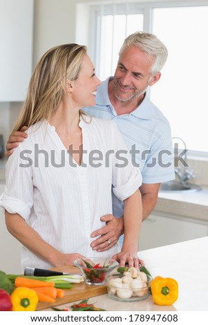 Happy couple preparing a healthy dinner together at home in the kitchen