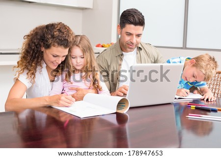 Cute young family at the table at home in kitchen