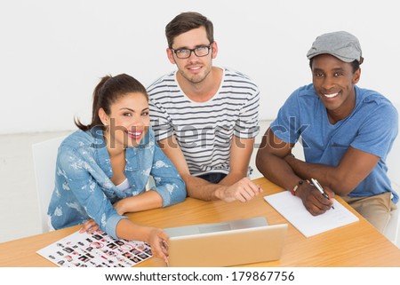 Portrait of three young artists working on laptop at the office