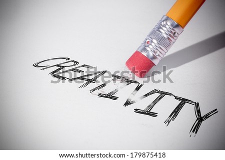 Pencil erasing the word creativity on paper