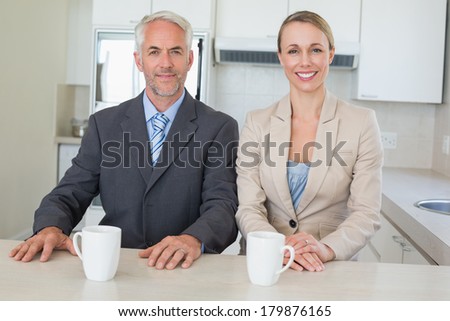 Happy business couple having coffee before work in morning at home in the kitchen