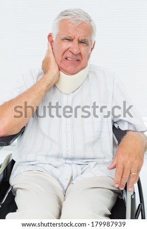 Portrait of a senior man sitting in wheelchair with cervical collar at the medical office
