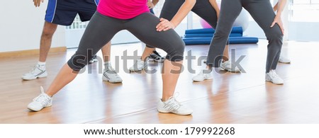 Low section of people doing power fitness exercise at yoga class in fitness studio